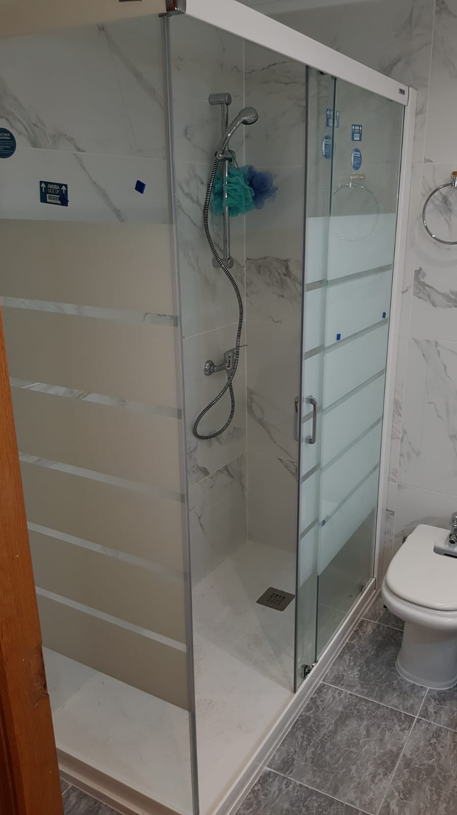 Mampara de baño con decoración blanca.