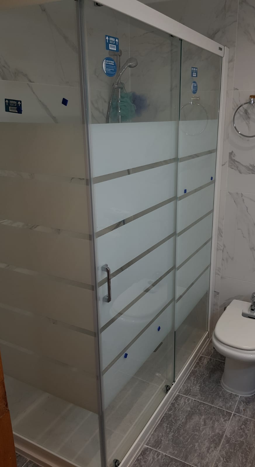 Mampara de baño con decoración blanca.