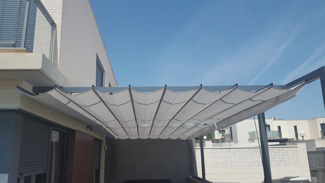 Toldo patio tipo andaluz entre paredes de color blanco con motorización