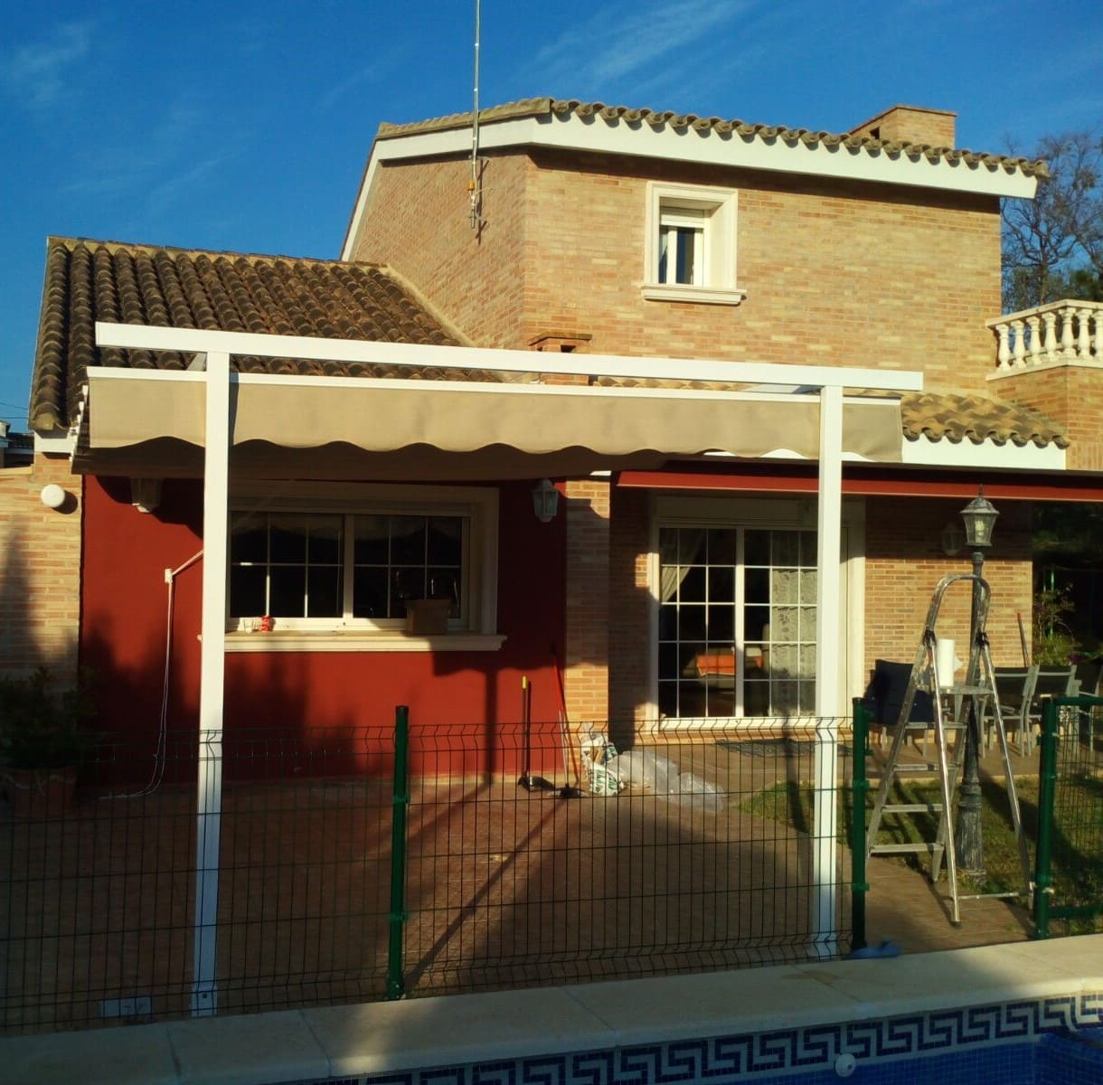 Toldo patio tipo andaluz entre paredes de color blanco con motorización