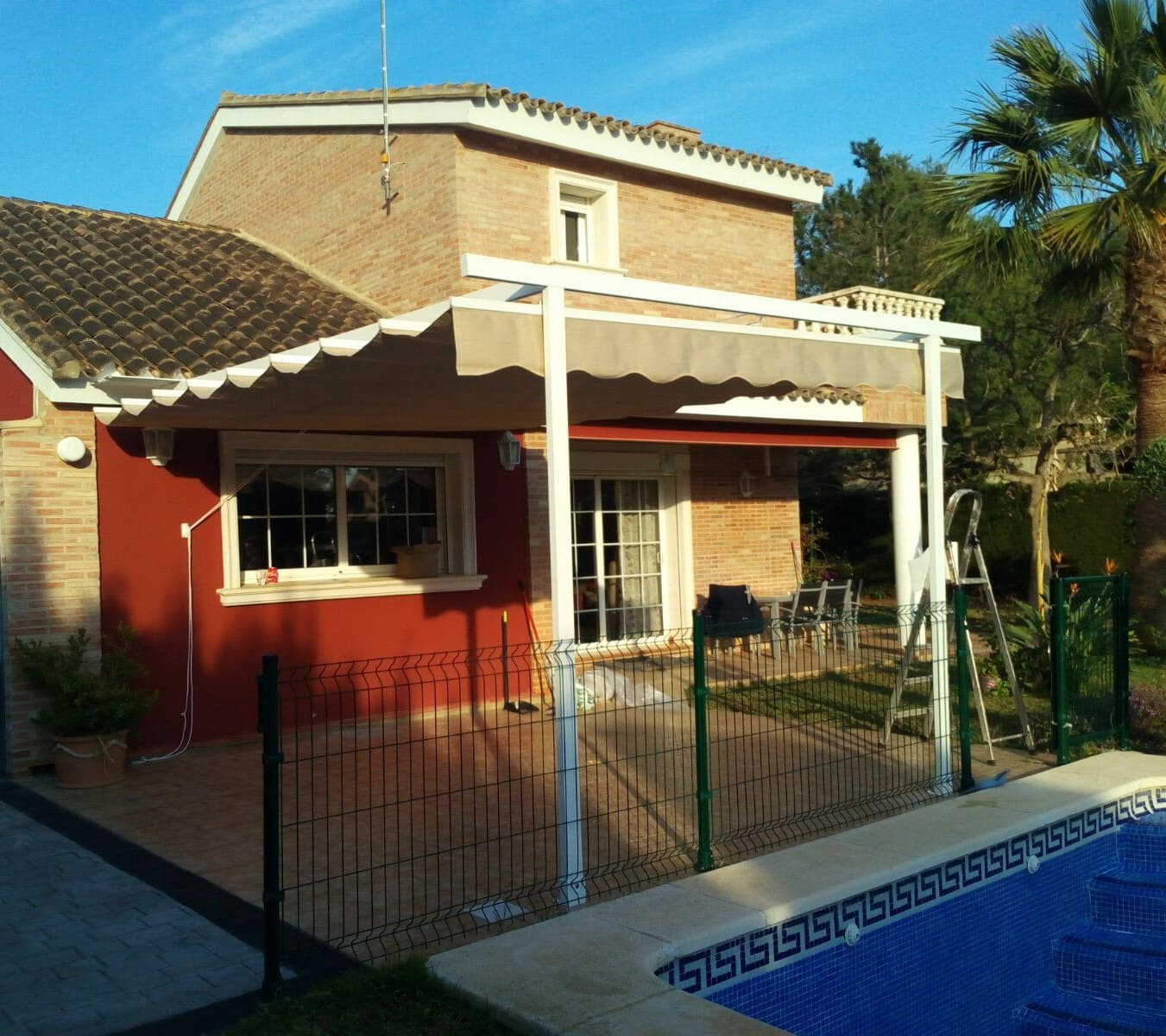 Toldo patio tipo andaluz entre paredes de color blanco con motorización