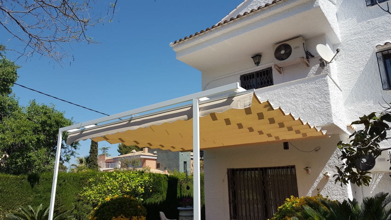Toldo patio tipo andaluz entre paredes de color blanco con motorización