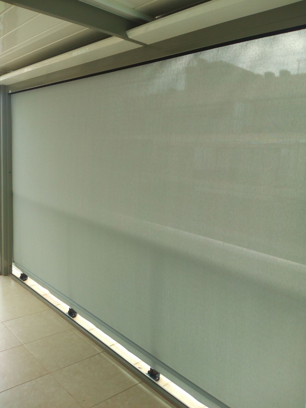 Instalación de persiana blanca en una terraza